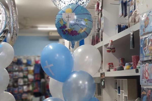 45cm light blue confetti balloon with 45cm round “First Communion” foil balloon with 3 rows of 2 balloons.

Top row - light blue balloon with white printed cross & white balloon.
Middle row - light blue balloon & white balloon.
Bottom row - light blue balloon with white printed cross & light blue balloon.